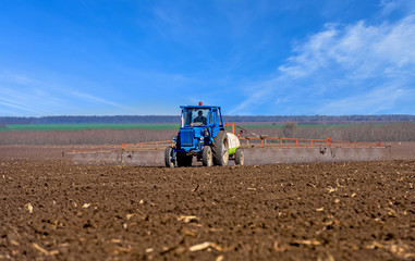 Naklejka premium Farm machinery spraying insecticide to field.