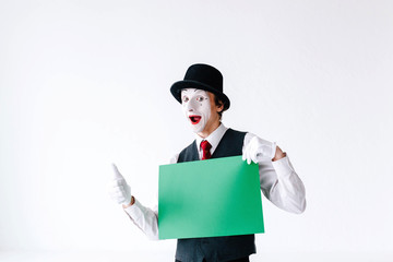 Mime holds thumb up before a green card