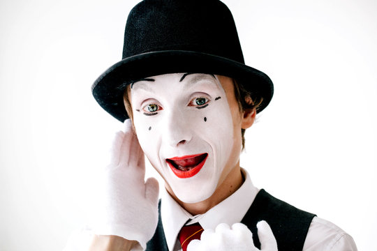 Mime in black hat with red lips hears something