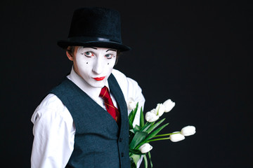 Mime hides bouquet of white tulips behind his back
