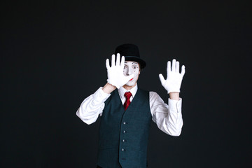 Mime holds his hands on invisible glass
