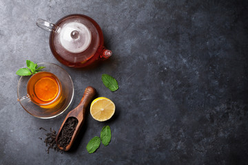 Tea cup, teapot and dry tea in spoon