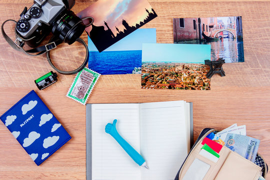 Top view. Objects of a traveller isolated on wooden background: notebook with a pen, wallet with money, passport, film, camera, ticket, photos of italy, turkey, france and souvenir