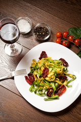 Dish - pasta with dried tomatoes and spices On a wooden table