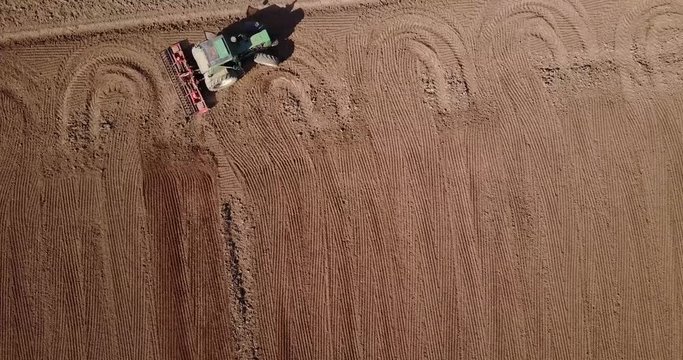 Trattore che ara i campi, vista aerea di un campo arato ed un trattore che semina. Agricoltura e coltivazione, campagna