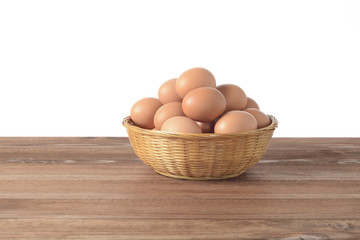 Huevos en un cesto de mimbre sobre fondo de madera marrón