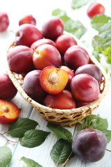 Fresh plums on a white wooden table