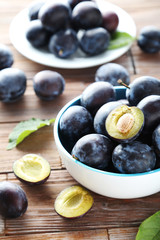 Tasty and ripe plums on brown wooden table