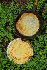 Жареные блины на сковороде и тарелке