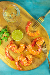 Glass of white wine with cooked shrimps, lime, and cilantro
