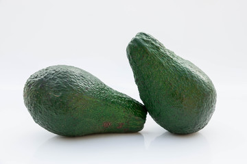 due avocado verdi su fondo bianco 