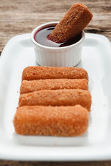 Delicious nuggets are served with superior red sauce on white plate, close up view. Restaurant menu photo.