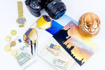 Top view. Objects of a traveler isolated on white background: envelope, souvenir, camera, cash, sunglasses, watch, photos of Turkey and the sea and passport with visas