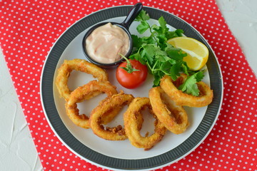 Calamary rings fried with spicy souce and rocca. Mediterranean lifestyle. Healthy food