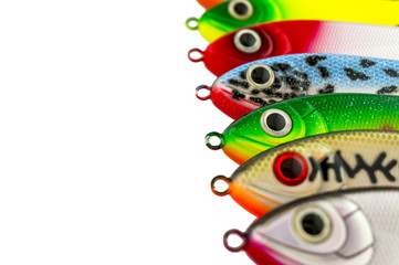 Fishing lures standing in a row. Multicolored fishing lures isolated on white background.