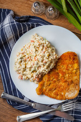 Fried pork chop in breadcrumbs, served with vegetable salad.