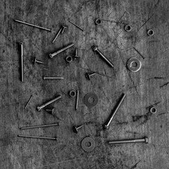 Set of golden screws, bolts, nails, washers, nuts on wooden background
