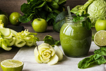 Detox diet. Green smoothie with different vegetables on wooden background