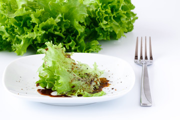 White plate with salad leaf