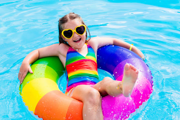 Child with toy ring in swimming pool
