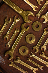Set of golden repair tools on rusty background