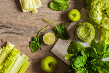 Detox diet. Green smoothie with different vegetables on wooden background