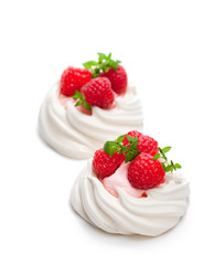 Mini  Pavlova meringue nests with berries and thyme on isolated on white