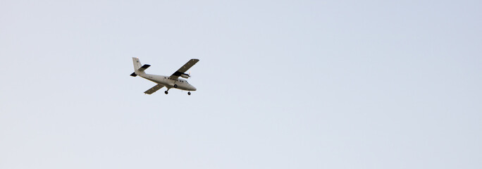 Private airplane flying, isolated on a bright blue sky