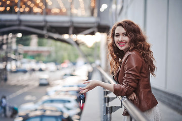 Beautiful young girl on the street with keys from the car