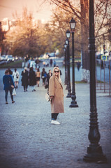 Young beautiful girl in coat walking