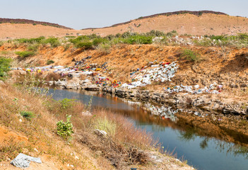 Colorful clothes hanging out to dry on the sandy banks of indian Puttaparthi village.
