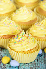 Yellow Easter cupcakes with sprinkles and candy eggs