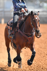 A front view of a rider sliding the horse in the dirt
