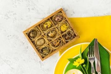 Easter quail eggs in wooden box with flowers . Easter background 