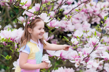 Obraz na płótnie Canvas Child with magnolia flower. Little girl with flowers