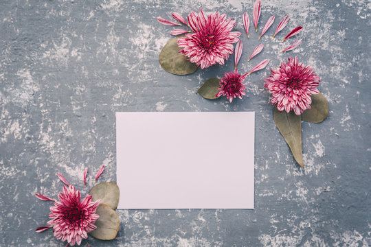  Paper blank and pink flowers on white background. Mockup with flowers. Flat lay, top view