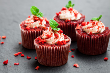 Strawberry  cupcakes with butter cream on black stone background