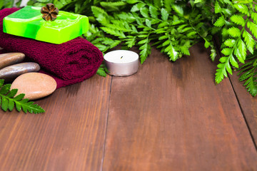 Obraz na płótnie Canvas Fresh green fern, candle, stones, green soap and towel for spa