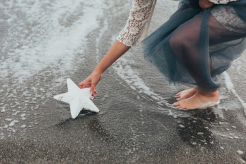 Hands touching  star on the beach 