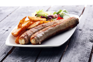 grilled sausages and potatoes and salad