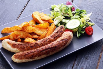 grilled sausages and potatoes and salad