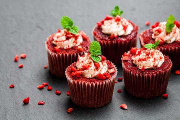 Strawberry  cupcakes with butter cream on black stone background