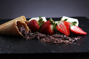 ice cream cones with white chocolate block and dark chocolate rasp and strawberries