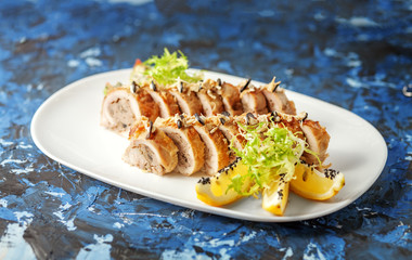 Delicious chicken with sauce rolls on a blue background. The concept of nourishing food.