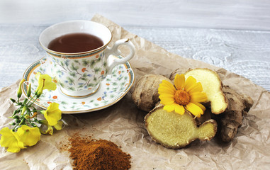 A cup of tea on a table with ginger and ground turmeric. Concept of health.