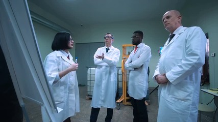 The supervisor explaining to the engineers the plan from the whiteboard in the office.