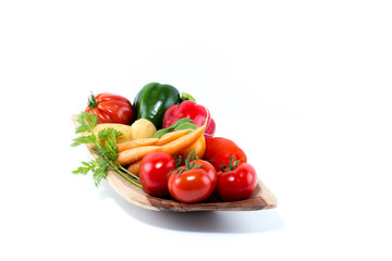 Vegetables in a handmade natural real wood bowl - tomatoes, carrots, pepper, potatoes