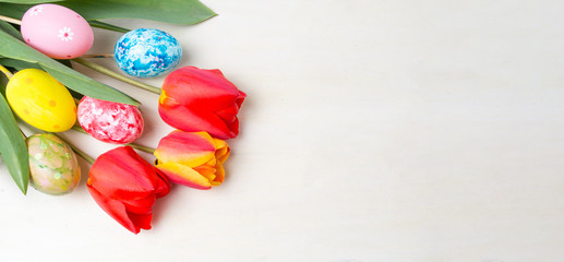 Fototapeta na wymiar Red tulips and painted Easter eggs