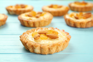 Naklejka na ściany i meble Delicious crispy tarts with almond and raisins on wooden background