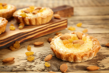 Delicious crispy tart with almond and raisins on wooden table